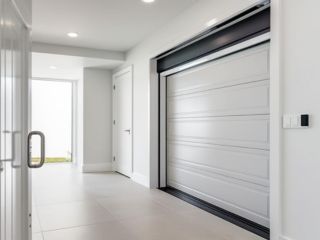 Modern Painted Garage Door with Sleek Hardware – Magna Home Bright, modern garage interior in Magna, Utah, featuring a freshly painted white garage door with recessed panels and stylish black hardware.
