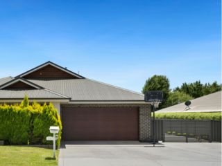 Modern Home with New Double Garage Door – Magna Front view of a contemporary house in Magna featuring a sleek double garage door, manicured lawn, and clear blue sky.